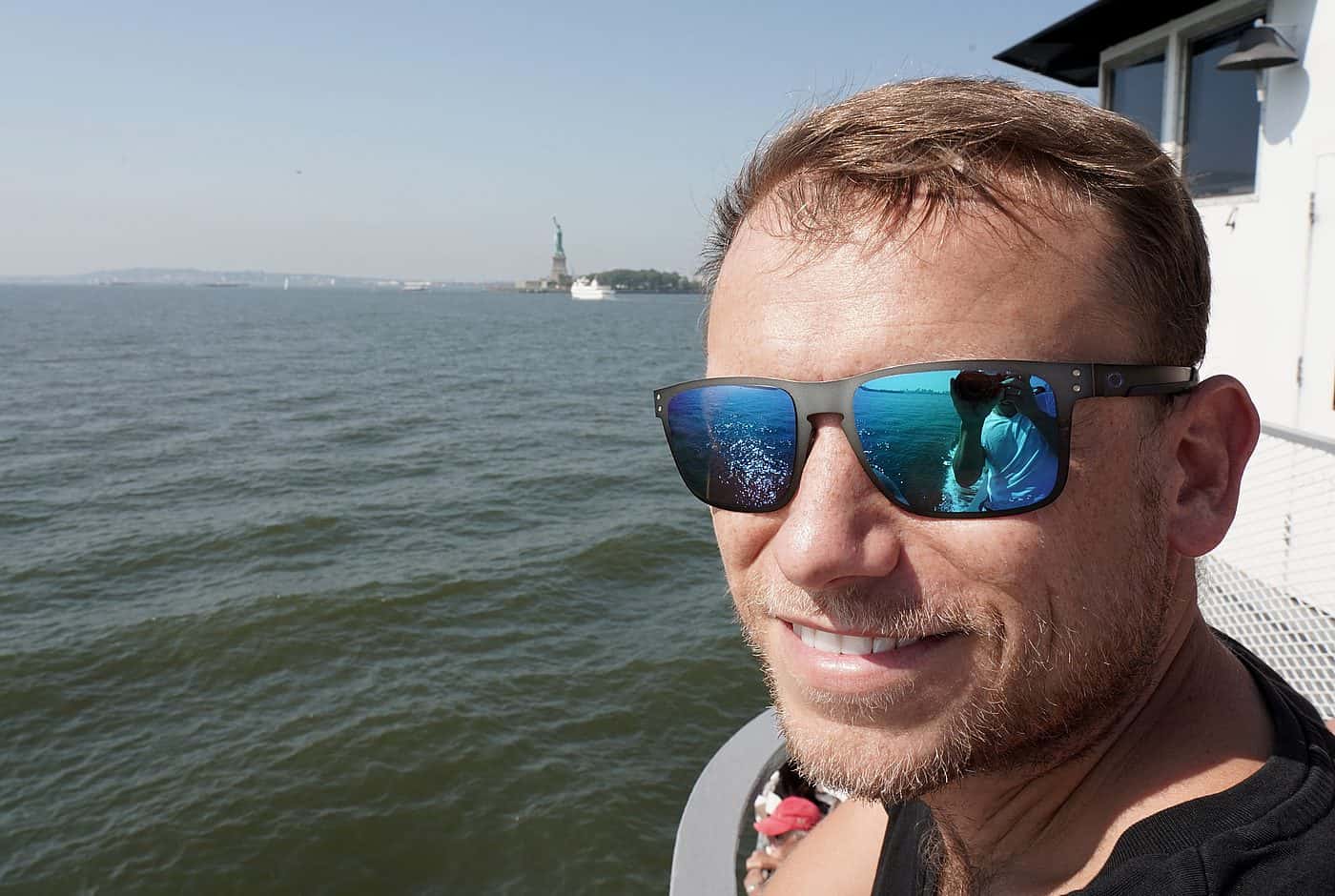 New York City – Arne bei Bootstour auf Hudson River, die Freiheitsstatue am Horizont zu sehen