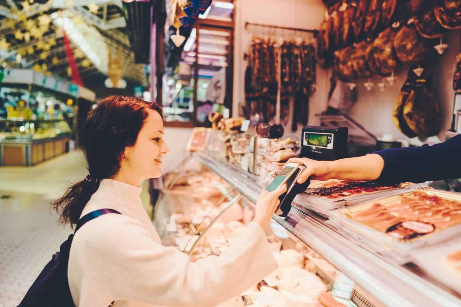 Reise Kreditkarte auf dem Markt mit dem Handy Bezahlen
